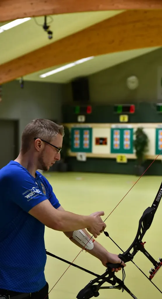 Mann spannt seinen Bogen mit einem Pfeil