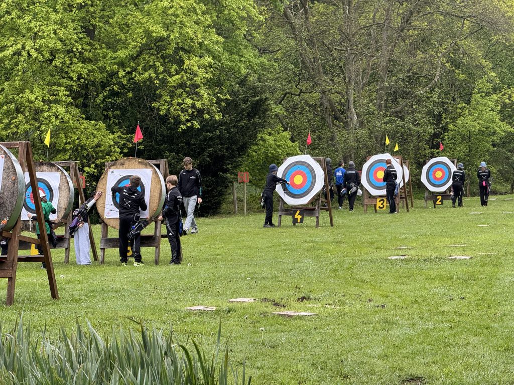 Schützen und Schützinnen beim Ziehen der Pfeile aus den Zielscheiben